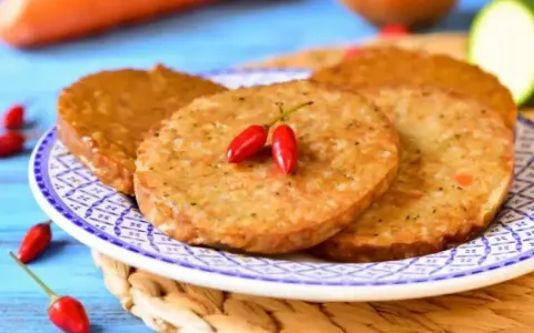 Plasterki seitanu, smażone na złoto, ozdobione dwoma papryczkami chili. Idealne do wegańskich burgerów. Seitan co to? To roślinne białko!