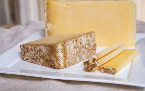 Tranches de Cantal, une des spécialités du Cantal, sur une assiette blanche.
