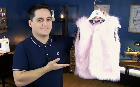 Un homme présente un adorable gilet berger bébé en fausse fourrure rose. Un patron gratuit pour le coudre est disponible.