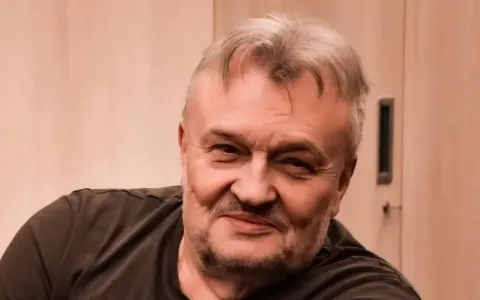 Uśmiechnięty Krzysztof Cugowski, z siwiejącymi włosami i zarostem. Zastanawiasz się, ile lat ma Krzysztof Cugowski?