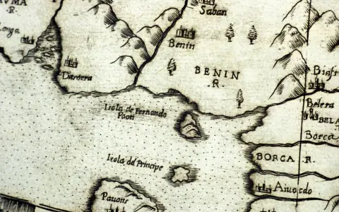 Fragment starej mapy ukazujący wybrzeże z zaznaczonym miastem Benin. Widać góry, rzeki i wyspy, jak Isola de Fernando Paon. Benin dawniej.
