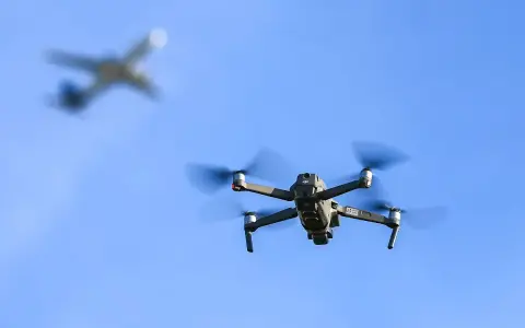 Drohne fliegt im Himmel, ein Flugzeug im Hintergrund. Wichtig: Drohne Haftpflicht für sichere Flüge.