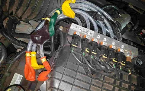 Motorkomponenten mit bunten Ballons an Leitungen. Mögliche Symptome eines defekten Benzinpumpenrelais sind hier zu sehen.