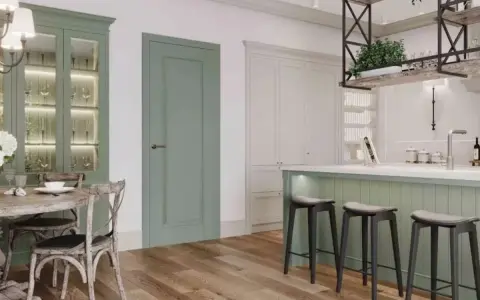 Elegancka kuchnia z wyspą w kolorze szałwiowym, przeszkloną witryną i drewnianą podłogą.
