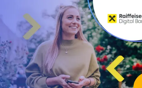 Uśmiechnięta kobieta z telefonem w dłoni, korzystająca z aplikacji Raiffeisen Digital Bank. Zastanawia się nad najlepszą lokatą bankową.