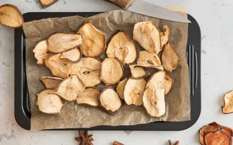 Suszone plastry gruszki na blasze, gotowe do chrupania.