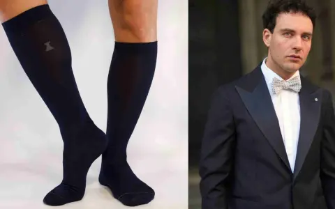 Un uomo elegante con smoking e papillon abbinato a calzini scuri.