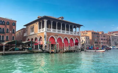 Le marché du Rialto à Venise, avec ses étals colorés et ses gondoles sur le Grand Canal.