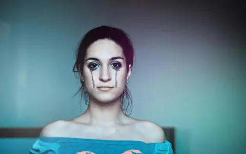 Ragazza con trucco che simula lacrime, espressione di labilità emotiva, alla ricerca di cura e comprensione.
