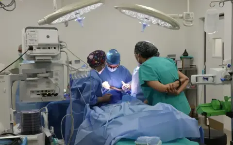 Zespół medyczny podczas operacji. Pielęgniarka operacyjna czuwa nad przebiegiem zabiegu, świadoma potencjalnych problemów prawnych w pracy.