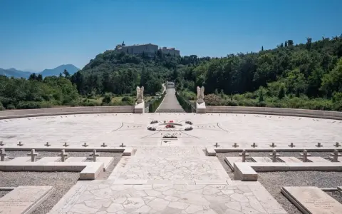 Cmentarz żołnierzy polskich, gdzie jest Monte Cassino. Monumentalny widok na wzgórze z opactwem, schody, krzyże i kamienne nagrobki.