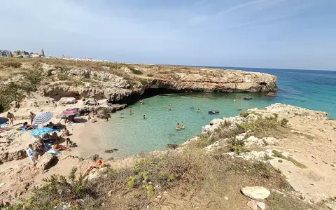 Una splendida giornata alla spiaggia di Porto Verde, con bagnanti che si godono il sole e le acque cristalline.