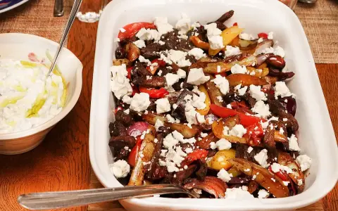 En härlig grekisk pyttipanna med potatis, paprika, lök och oliver, toppad med fetaost. Serveras med en krämig tzatziki.