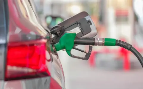 Tankowanie Kia Ceed 1.6 benzyna. Zielony pistolet paliwowy wlewa paliwo do baku.