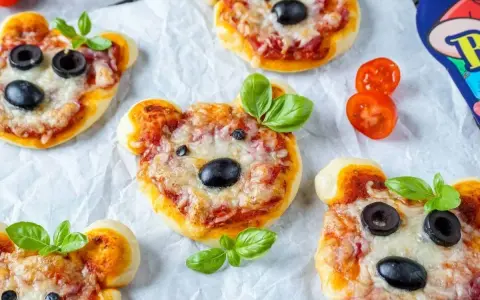 Niedliche mini pizza-Bären mit Oliven und Basilikum.