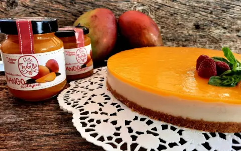 Deliciosa tarta de mango y queso, con mermelada ecológica de mango y frambuesas frescas.