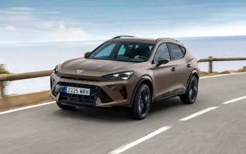Brązowy SUV Cupra jedzie po drodze nad morzem.