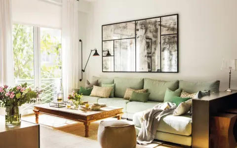 Un espejo grande y decorativo es una excelente idea de qué poner detrás del sofá, aportando amplitud y estilo a la sala.