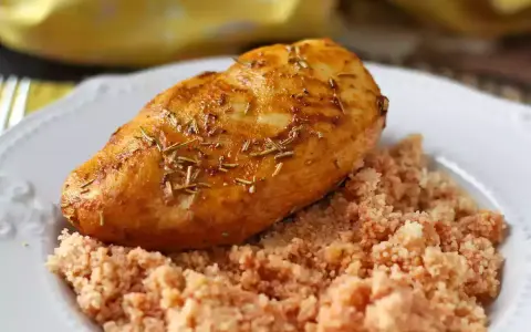 Deliziosi fusi di pollo in friggitrice ad aria, dorati e profumati al rosmarino, serviti su un letto di couscous.