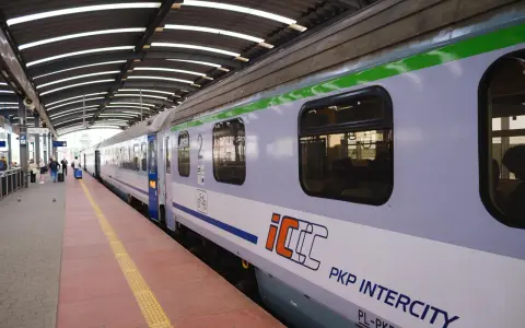 Pociąg PKP Intercity na peronie, z widocznymi oknami i logo.