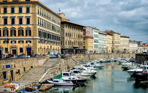 Edifici storici e barche ormeggiate lungo il canale del **terminal crociere Livorno**.