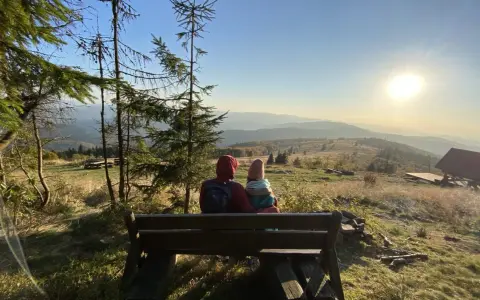 Para siedzi na ławce, podziwiając widok na Beskid Wyspowy. To z pewnością najładniejszy szlak na Mogielicę, z tak pięknym zachodem słońca.