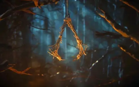 W lesie wisi symbol przypominający literę "A", wykonany z gałązek i sznurka. To znak z gry Assassin's Creed Hexe.