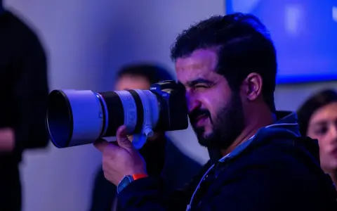 Un fotografo con una Canon EOS scatta foto, pensando a quanto guadagna un fotografo.