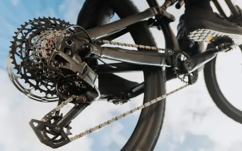 Nahaufnahme einer SRAM Schaltung am Fahrrad. Die Kette läuft über die Kassette, während ein Schuh auf dem Pedal zu sehen ist. Perfekt, um die SRAM Schaltung einzustellen.