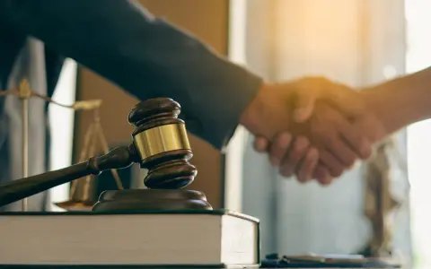 Młotek sędziowski i waga sprawiedliwości symbolizują zakończenie sprawy. Ugoda sądowa i co dalej – porozumienie osiągnięte.