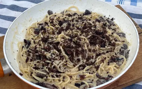 Spaghetti cremosi con olive nere e una spolverata di cacao amaro, un'originale pasta alla cenere.