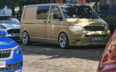 Złoty bus, przeróbka busa na kampera przepisy. Stylowe felgi, naklejki i palma na boku.