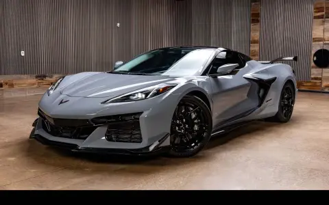 Szary Chevrolet Corvette C8, jeden z najnowszych chevrolet modele, prezentuje się dynamicznie na tle nowoczesnego wnętrza.