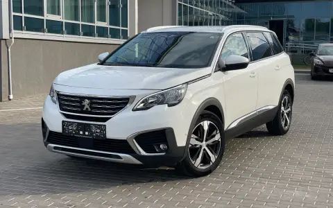 Biały Peugeot 5008 na parkingu. Wiele osób szuka peugeot 5008 opinie, ten SUV to świetny wybór.