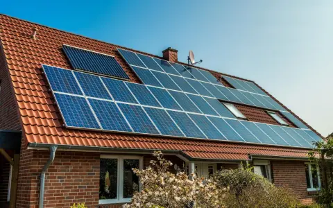 Ett tegelhus med solpaneler på taket, en del av solenergi historia.