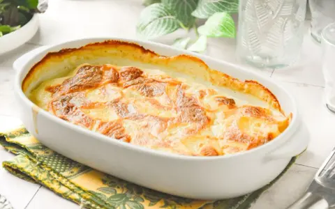 Graten de patatas cremoso y dorado, recién salido del horno, listo para ser disfrutado.