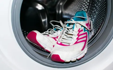 Zapatillas deportivas blancas con detalles fucsia y turquesa listas para aprender como lavar zapatillas en la lavadora.