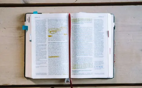 Ein aufgeschlagenes Buch mit Bibeltexten, das die Frage "was bedeutet evangelisch" beleuchtet.