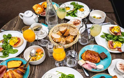 Un festin matinal parisien : œufs Bénédicte, croissants, jus d'orange et café. Un plat typique de Paris pour bien commencer la journée.