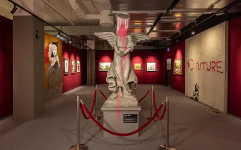 Banksy-utställning i Stockholm med en skulptur av en ängel med en färgburk på huvudet och texten "NO FUTURE".