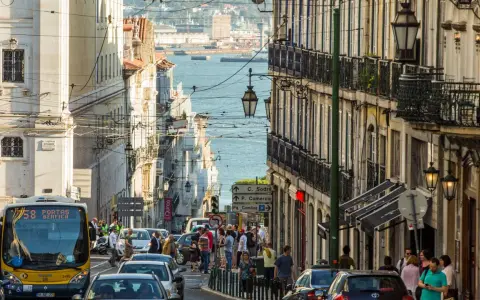 Ein belebter Tag in Lissabon, wo die portugiesischen Einwohner die engen Gassen mit ihren historischen Gebäuden und dem Blick auf das Wasser beleben.