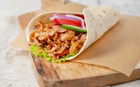 Pyszny kebab w picie z soczystym mięsem, świeżymi warzywami i chrupiącą sałatą, gotowy do zjedzenia.
