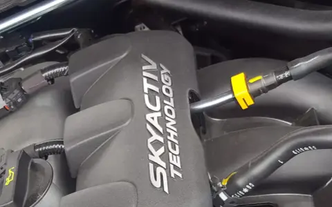 Silnik SKYACTIV TECHNOLOGY, prawdopodobnie najlepszy silnik benzynowy, z widocznymi przewodami i złączkami.