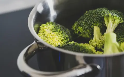 Brócoli fresco en una olla metálica, listo para cocción. El tiempo cocción brócoli olla normal es clave para su punto perfecto.