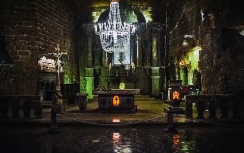 Wnętrze kaplicy w kopalni soli w Wieliczce, jednej z najpiękniejszych kopalnie do zwiedzania w Polsce. Kryształowy żyrandol, ołtarz i rzeźby z soli.