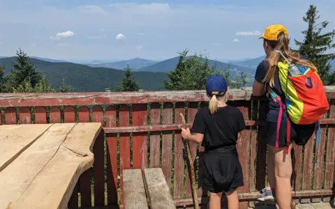 Dwie dziewczynki podziwiają malownicze widoki z tarasu. To idealne miejsce na odkrywanie widokowych szlaków blisko Krakowa.