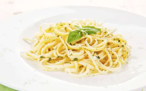 Ein Teller Spaghetti mit Kräutern und Parmesan, garniert mit Basilikum. Perfekt für einfache Spaghetti Rezepte.