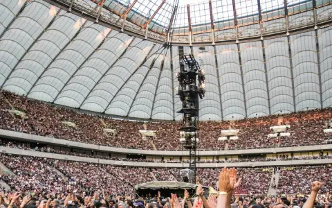 Roztanczony PGE Narodowy w Warszawie, tłumy ludzi na koncercie pod dachem stadionu.
