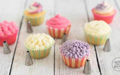 Bunte Muffins verzieren: Rosa, gelbe und lila Frosting-Kreationen mit Spritztüllen.