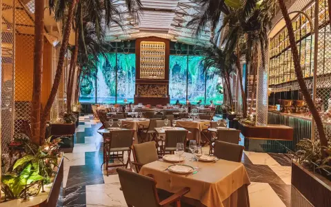 Tropische Atmosphäre in einem der Restaurants in Valencia. Palmen und ein Wasserfall-Bild im Hintergrund schaffen ein einzigartiges Ambiente.